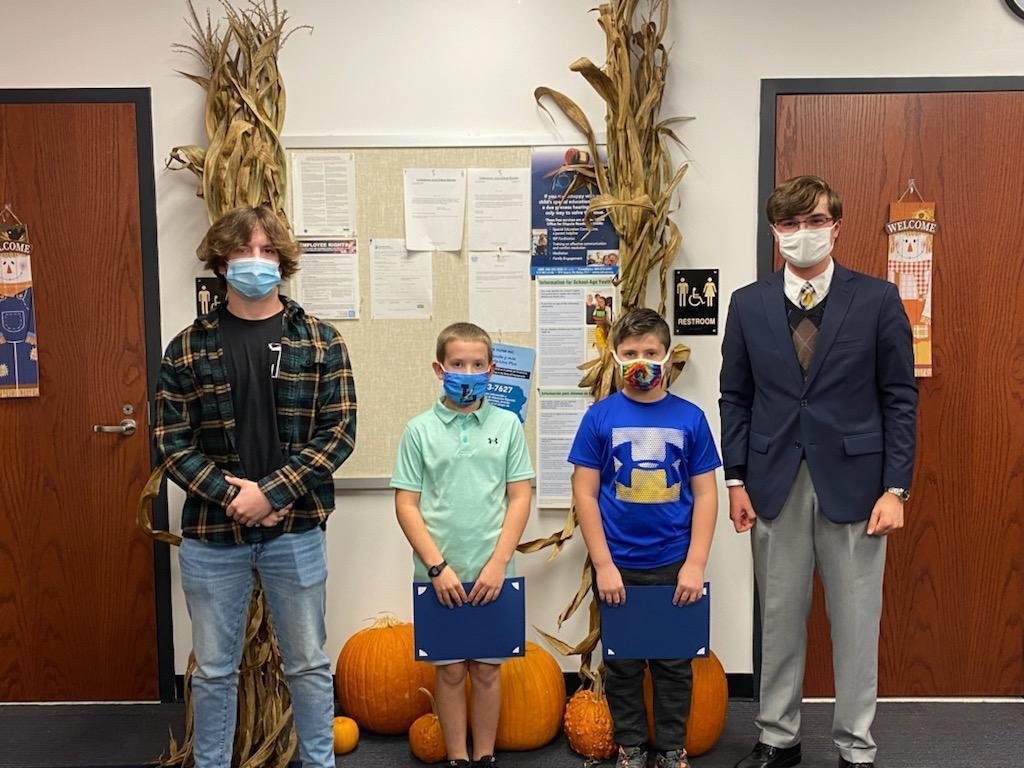 Students standing in front of fall background