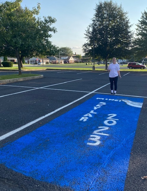 Senior Skylar Hahn after painting her Senior Parking Spot